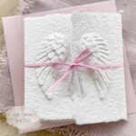 Glückwunschkarte zur Geburt mit Engelsflügeln und rosa Satinband