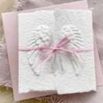 Glückwunschkarte zur Geburt mit Engelsflügeln und rosa Satinband