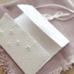 Geöffnete Einladung zur Kommunion mit Blümchen bunt