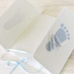 Individualisierbare Geburtsanzeige mit blauen Füsschen aus handgeschöpftem Papier.