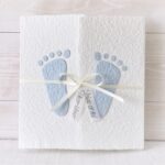 Individualisierbare Geburtsanzeige mit blauen Füsschen aus handgeschöpftem Papier.