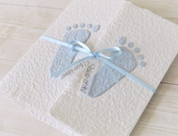 Individualisierbare Geburtsanzeige mit blauen Füsschen aus handgeschöpftem Papier.