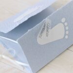 Individualisierbare Glückwunschkarte zum Baby blau mit weissen Füsschen aus handgeschöpftem Papier.