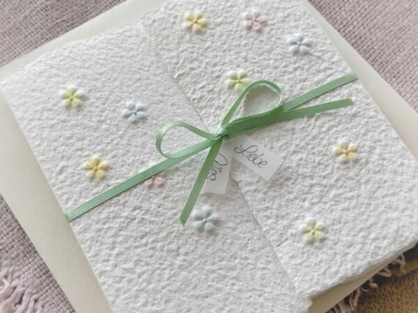 Nahaufnahme handgeschöpfte Glückwunschkarte "Blümchen" im Gatefold Design mit eingeprägten, handkolorierten Blüten