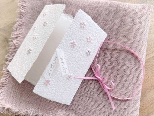 Handgeschöpfte Geburtsanzeige im geöffneten Gatefold Design mit eingeprägten und handkolorierten Blümchen
