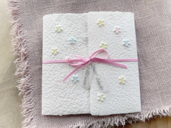 Handgeschöpfte Geburtskarte mit geprägten Blümchen, handbemalt in zarten pastell Farben.