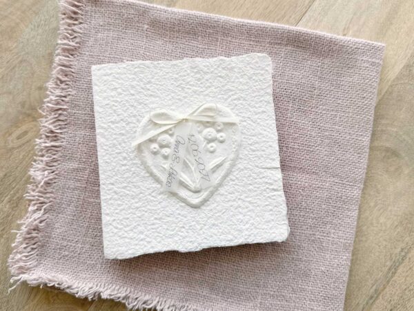 Handgemachte Hochzeitseinladung "Büttenherz" aus handgeschöpftem Papier weiss in weiss. Mit Namen des Brautpaares als Titel.