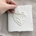 Schlichte, handgeschöpfte Hochzeitseinladung "Büttenherz" Papier weiss in weiss. Mit personalisiertem Titel auf zwei transparentpapierstreifen.