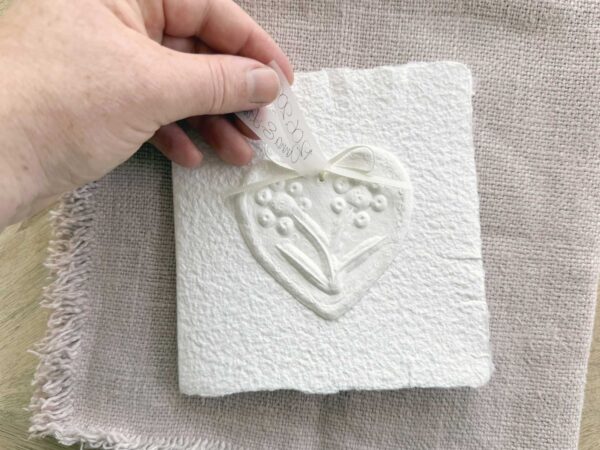 Schlichte, handgeschöpfte Hochzeitseinladung "Büttenherz" Papier weiss in weiss. Mit personalisiertem Titel auf zwei transparentpapierstreifen.