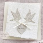 Exklusive Hochzeitseinladung «Tauben» aus handgeschöpftem Büttenpapier im Gatefold Desing mit zwei beigen Tauben und elegantem Satinband. Personalisierter Titel auf beigem Herz.