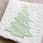 Detail der Mini-Karte Tannenbaum mit handgeschöpftem Papier, feinem Goldfaden, Halbperlen und kleiner Goldschleife