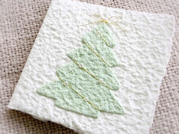 Detail der Mini-Karte Tannenbaum mit handgeschöpftem Papier, feinem Goldfaden, Halbperlen und kleiner Goldschleife