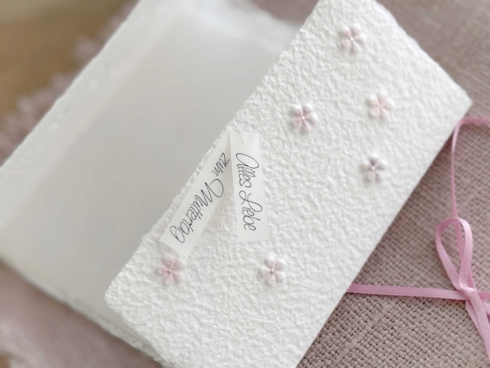 Nahaufnahme Muttertagskarte aus handgeschöpftem Papier im Gatefold Design mit eingeprägten, handkolorierten Blüten