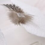 Trauerkarte aus handgeschöpftem Papier in weiss mit einer Feder, Titelstreifen und Satinschleifchen