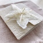 Exklusive Weihnachtskarte aus handgeschöpftem Papier mit gefilztem Stern mit Perlen und Satinband