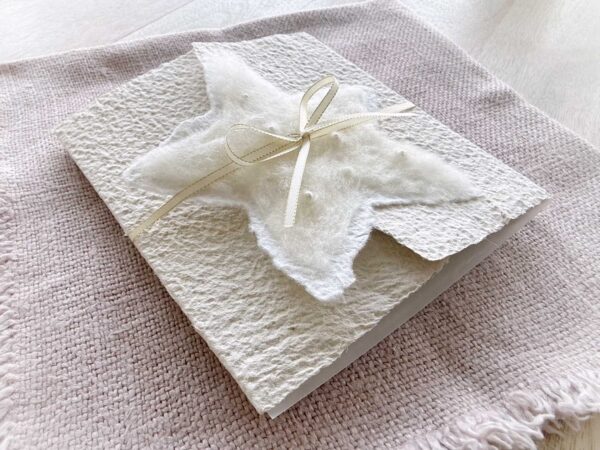 Exklusive Weihnachtskarte aus handgeschöpftem Papier mit gefilztem Stern mit Perlen und Satinband